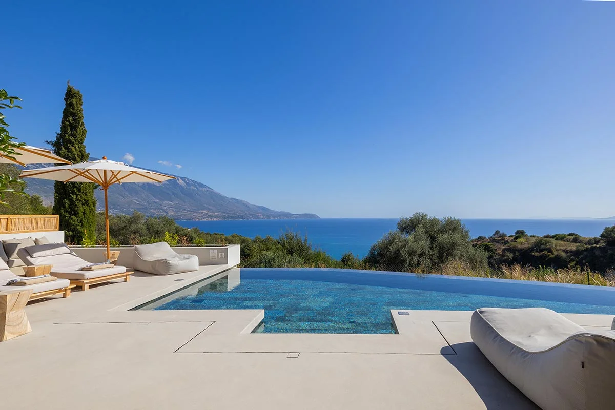 Infinity pool with loungers and mountain views overlooking the Ionian Sea at Eliamos in Kefalonia, Greece.