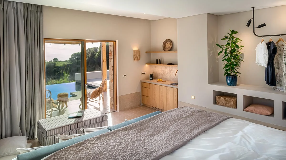 Modern bedroom with private pool view, open-air seating, and kitchenette at Eliamos in Kefalonia.