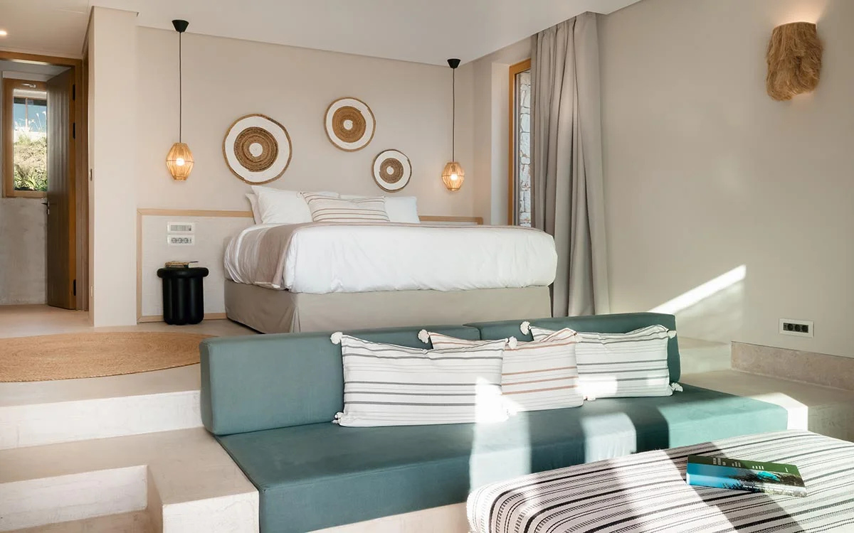 Elevated bedroom space with hanging lights and soft seating in a villa at Eliamos wellness resort in Kefalonia.