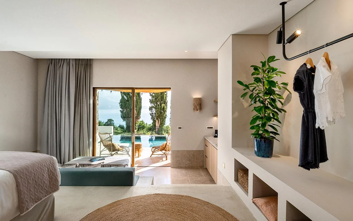 Elegant bedroom with neutral tones and poolside access at Eliamos in Kefalonia, Greece.
