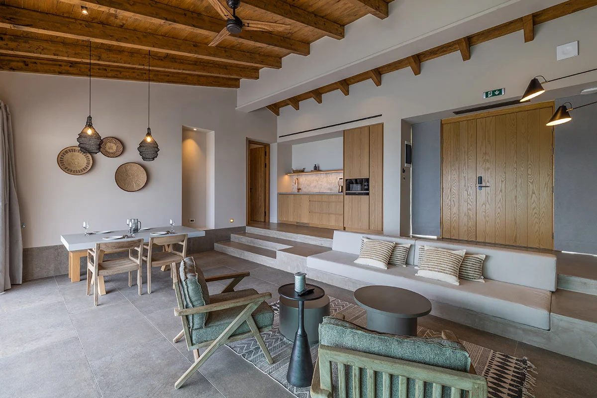 Spacious living and dining area with wood ceiling, modern decor, and stone flooring at Eliamos in Kefalonia.