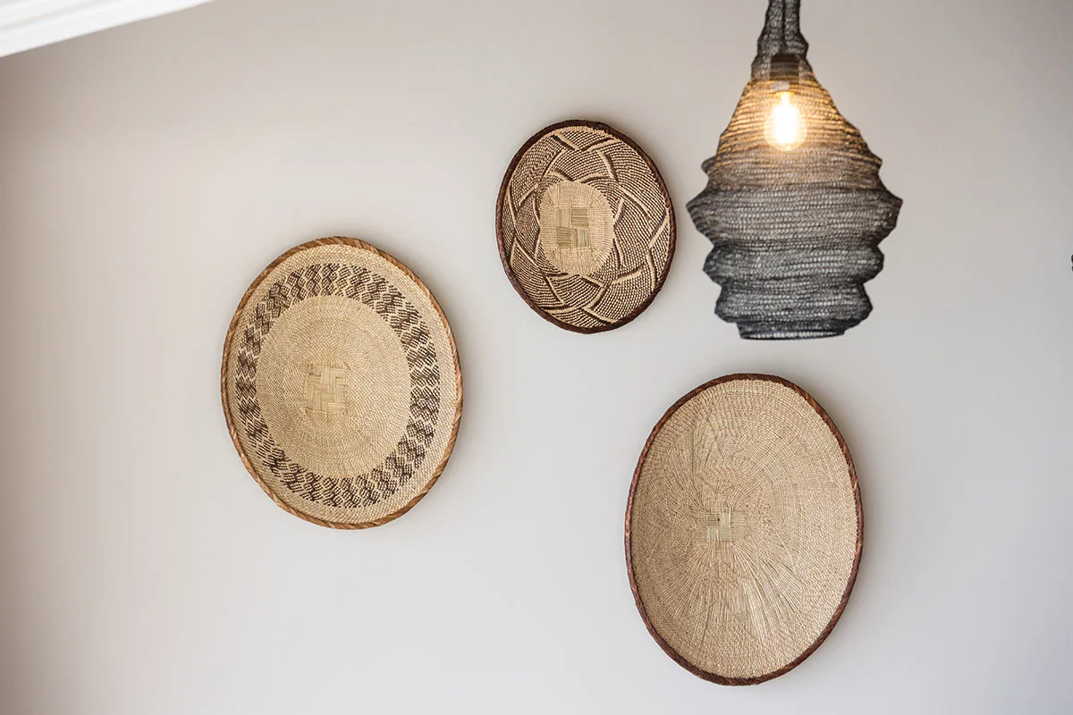 Woven basket wall art and hanging lamp in earthy tones inside Eliamos resort accommodation in Kefalonia.