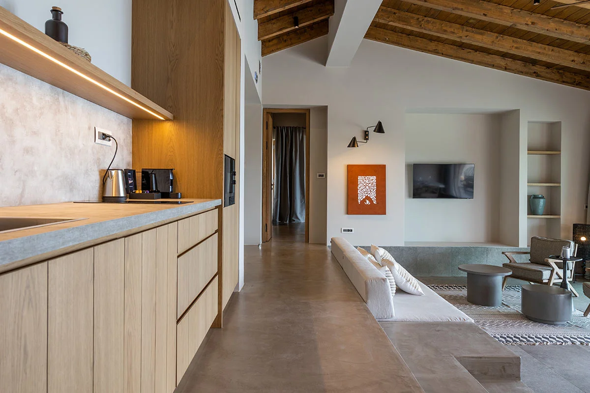 Contemporary kitchenette and sunken lounge area with wood ceiling at Eliamos luxury resort in Kefalonia.